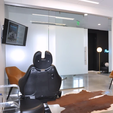 Consultation room at Pappas Orthodontics featuring dental chair, colorful artwork, and glass doors.
