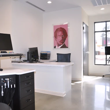 Open orthodontic workspace at Pappas Orthodontics featuring dental station, desk area, and artwork.